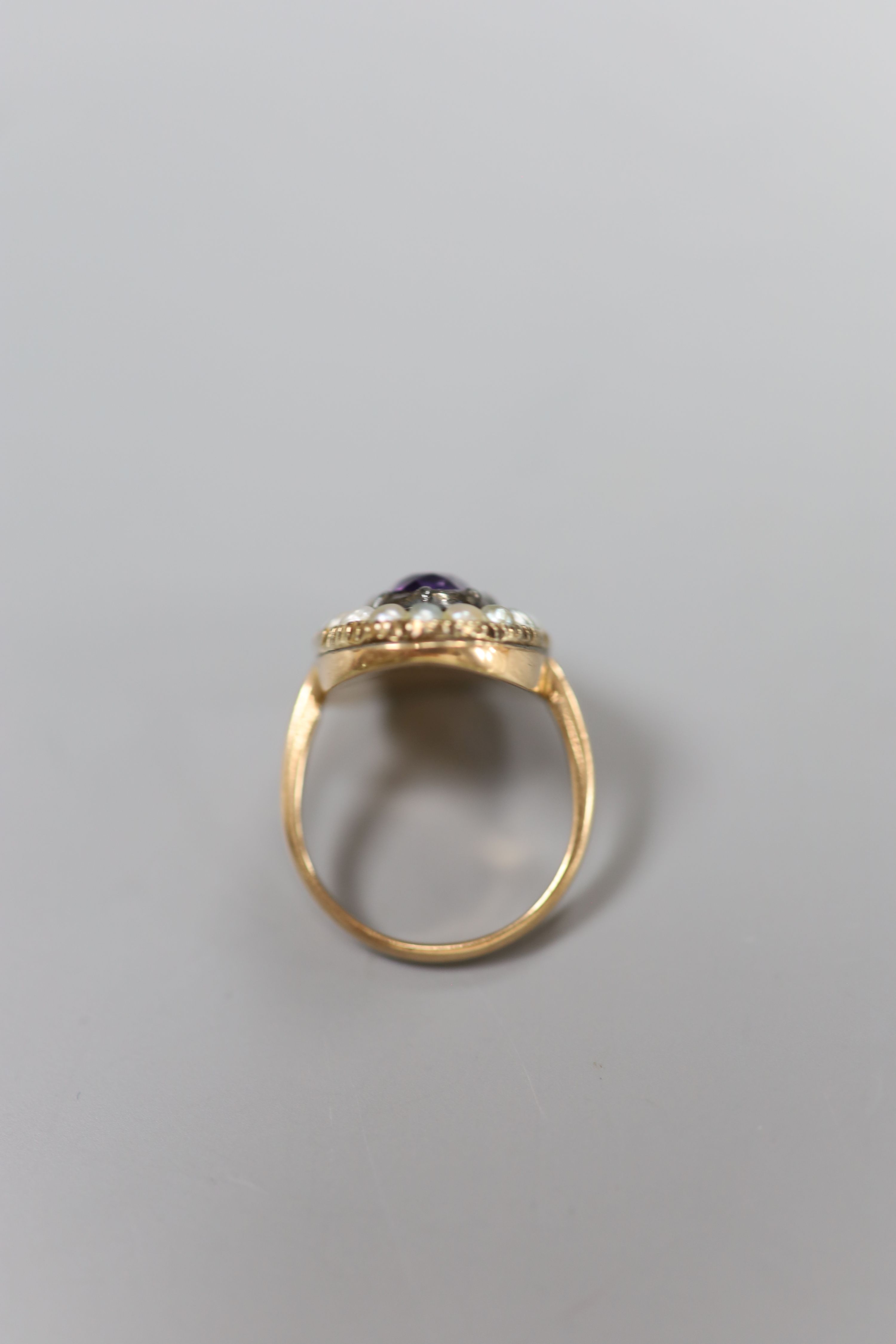 A 19th century, 9ct, amethyst and split pearl set oval cluster ring, size L, gross 5 grams.